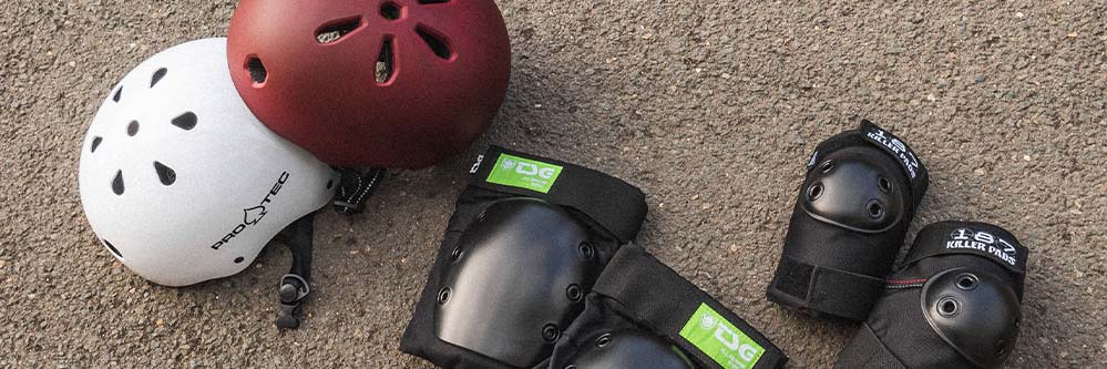 Casques de skateboard et vêtements de protection posés sur le sol