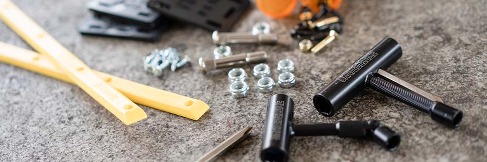 Skateboard spare parts and tools lie on a ledge