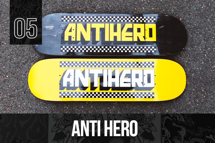 Two Anti Hero skateboard decks, one black and one yellow, both with bold Anti Hero logos and checkerboard graphics, displayed on pavement.