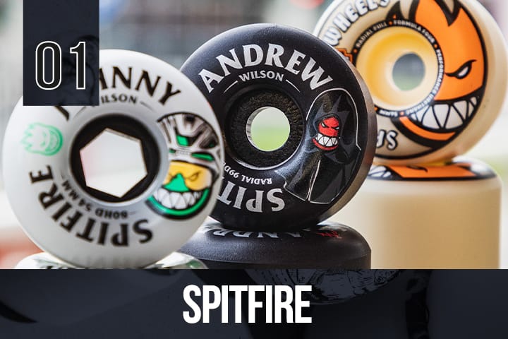 Assorted Spitfire skateboard wheels with bold branding and illustrated faces, arranged in a group, ideal for streetwear and skateboarding.