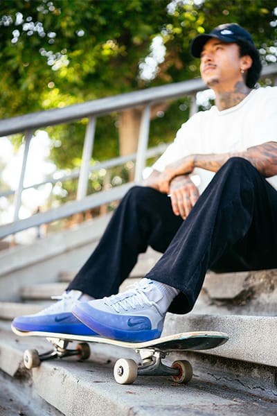 Nyjah Huston wears the Nike SB Zoom Nyjah 4 while skating on stairs with a board, focus on the shoe