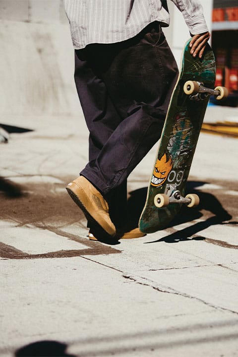 On-foot-Aufnahme der Vans Z3 in Braun mit Gum-Sohle, getragen von einem Skater, der auf der Stra&szlig;e mit dem Board in der Hand l&auml;uft.