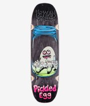 Planche de skateboard « Pickled Egg » 9" de Heroin Skateboards, vue de dessous : planche noire à motif bois avec, au centre, un personnage de dessin animé représentant un œuf mariné dans un bocal (couvercle bleu, liquide vert), le slogan rose « Pickled Egg » et le logo « Heroin Skateboards » en haut. Image de studio nette ; fond blanc.