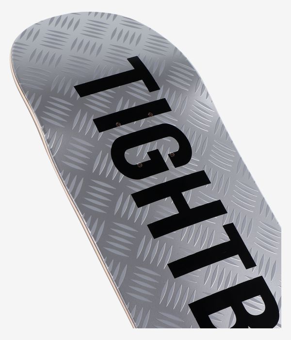 Nahaufnahme des Tightbooth CP Logo 8,38"-Skateboard-Decks: silbermetallische Oberfläche mit Riffelblech-Struktur und großem, diagonal verlaufendem schwarzem „Tightbooth“-Logo auf der Nose. Klares Studiobild; weißer Hintergrund.
