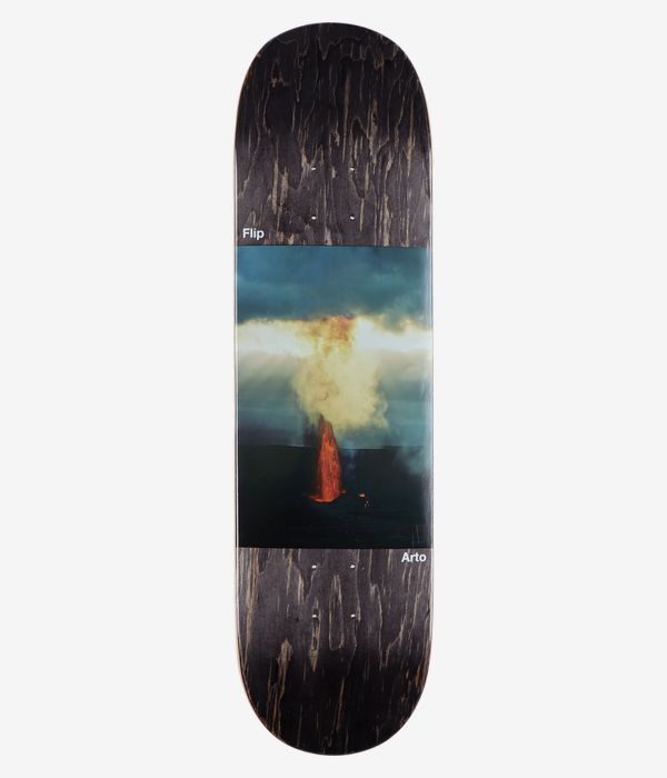 Flip Saari Explosion 8.5" Skateboard Deck, full bottom view: dark stained black wood-grain deck with central photographic panel of orange-red volcanic explosion and yellow-cream smoke against teal-blue sky; white 'Flip' and 'Arto' text visible. Clean studio image; white background.