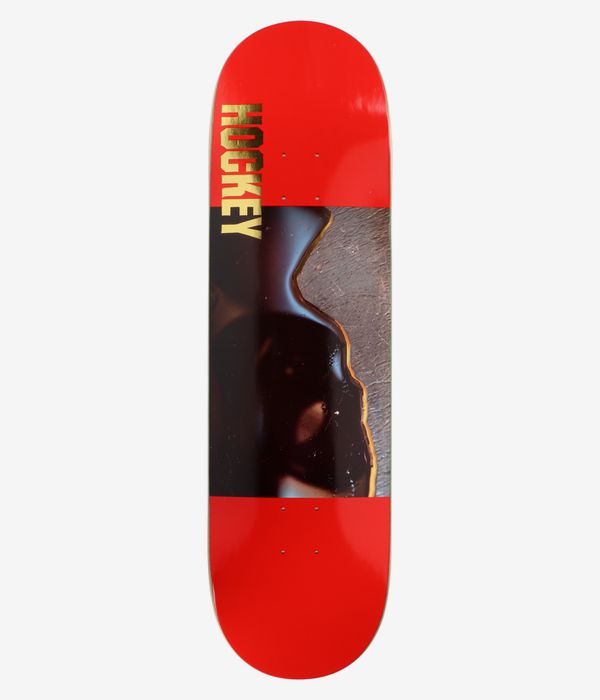 Planche de skateboard HOCKEY Insanitary Shape n° 1 de 9 pouces, vue de dessous : planche rouge vif ornée d'une grande illustration photographique abstraite noire brillante au centre, avec l'inscription « HOCKEY » en lettres dorées verticales sur le bord gauche ; image nette prise en studio, sur fond blanc.